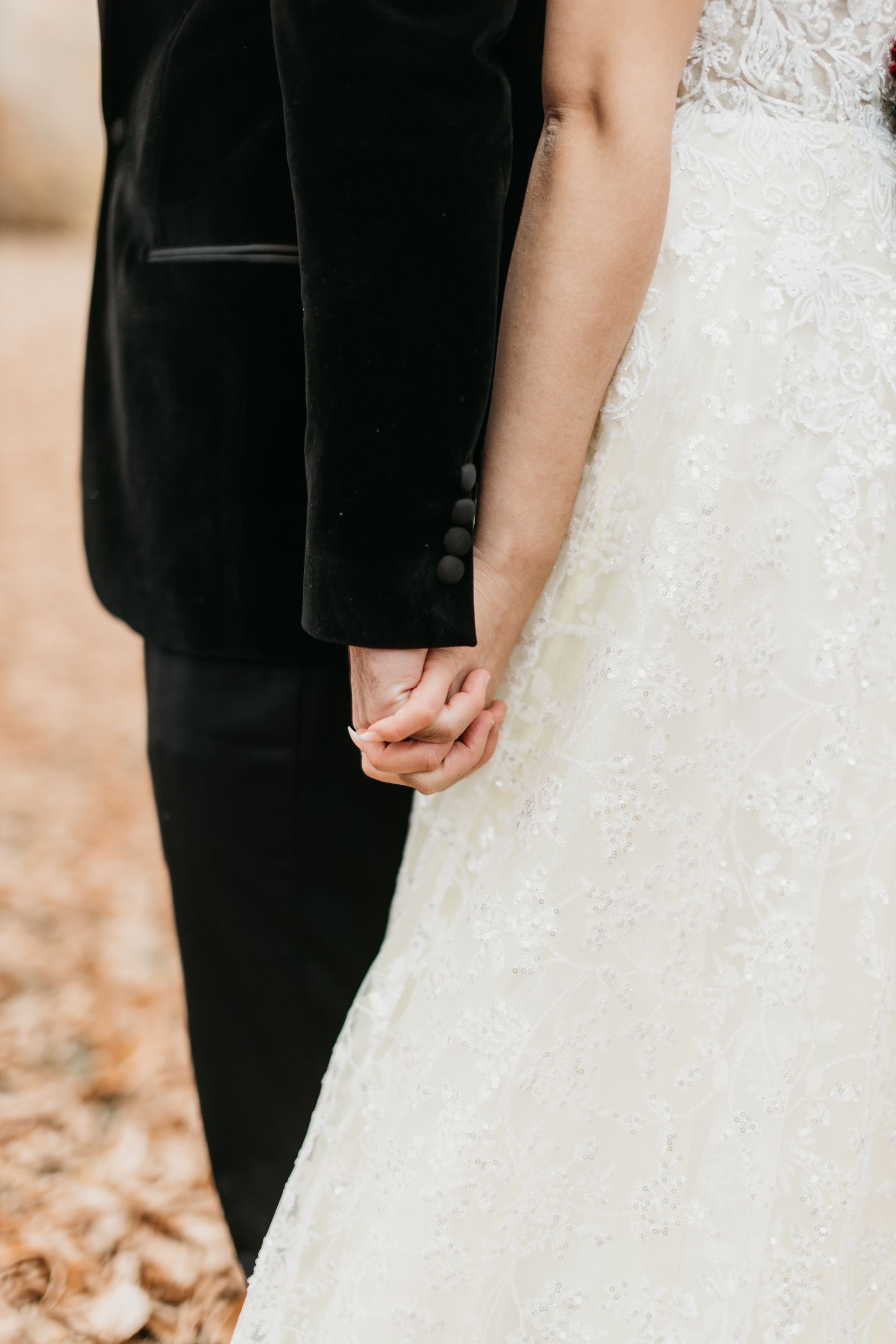 A bride and groom are holding hands on their wedding day.