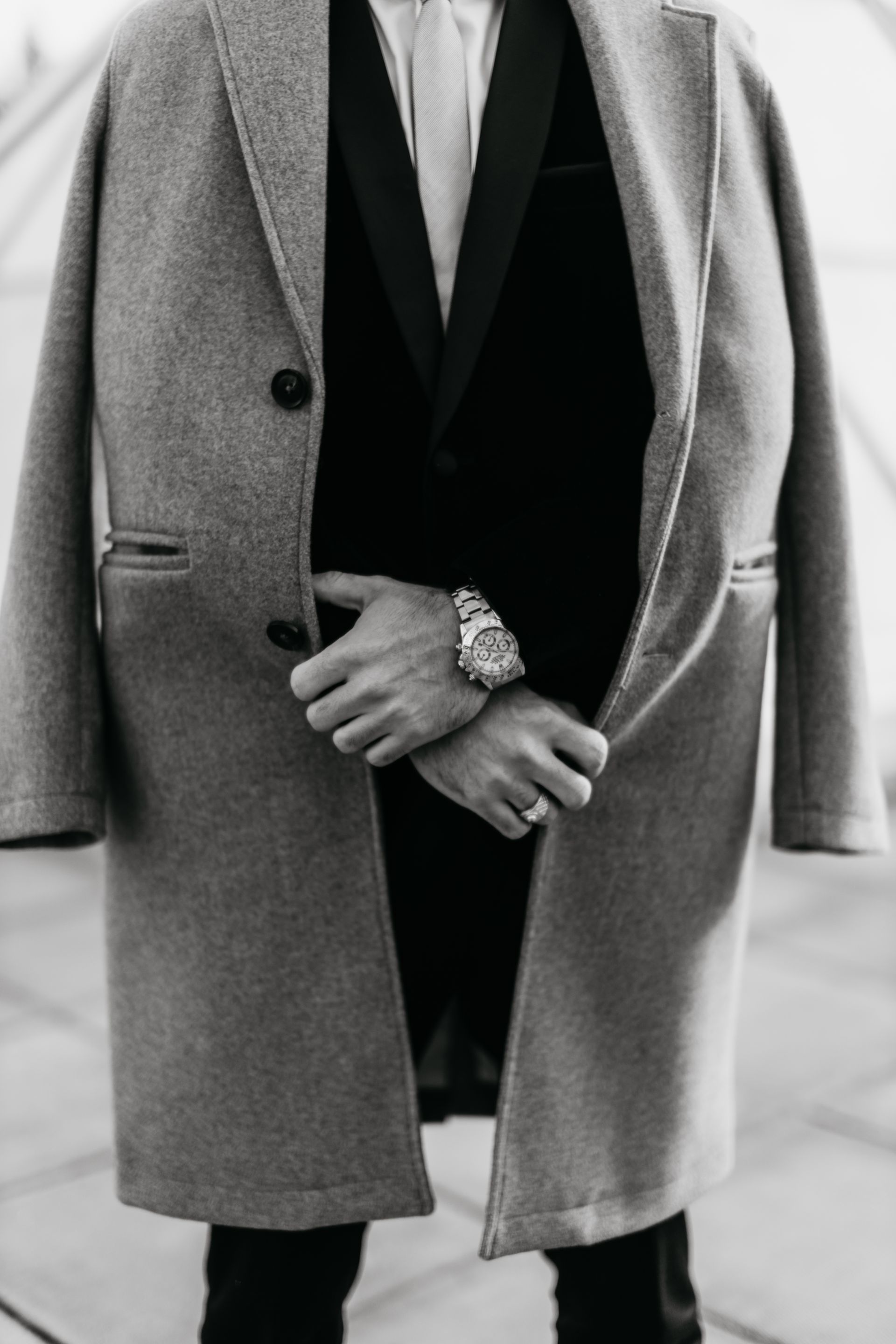 A black and white photo of a man in a suit and coat.