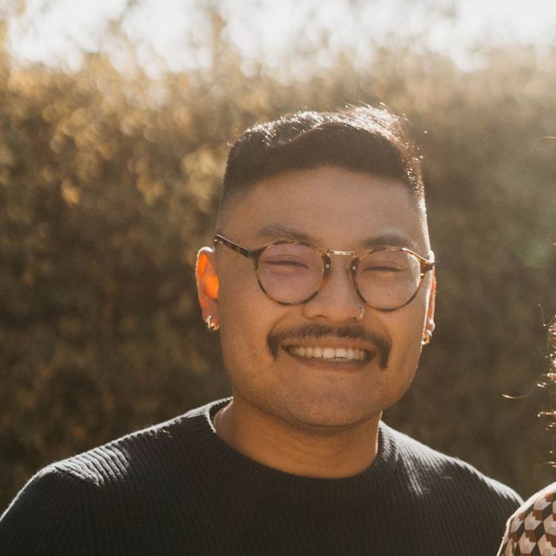 A man with glasses and a mustache is smiling for the camera
