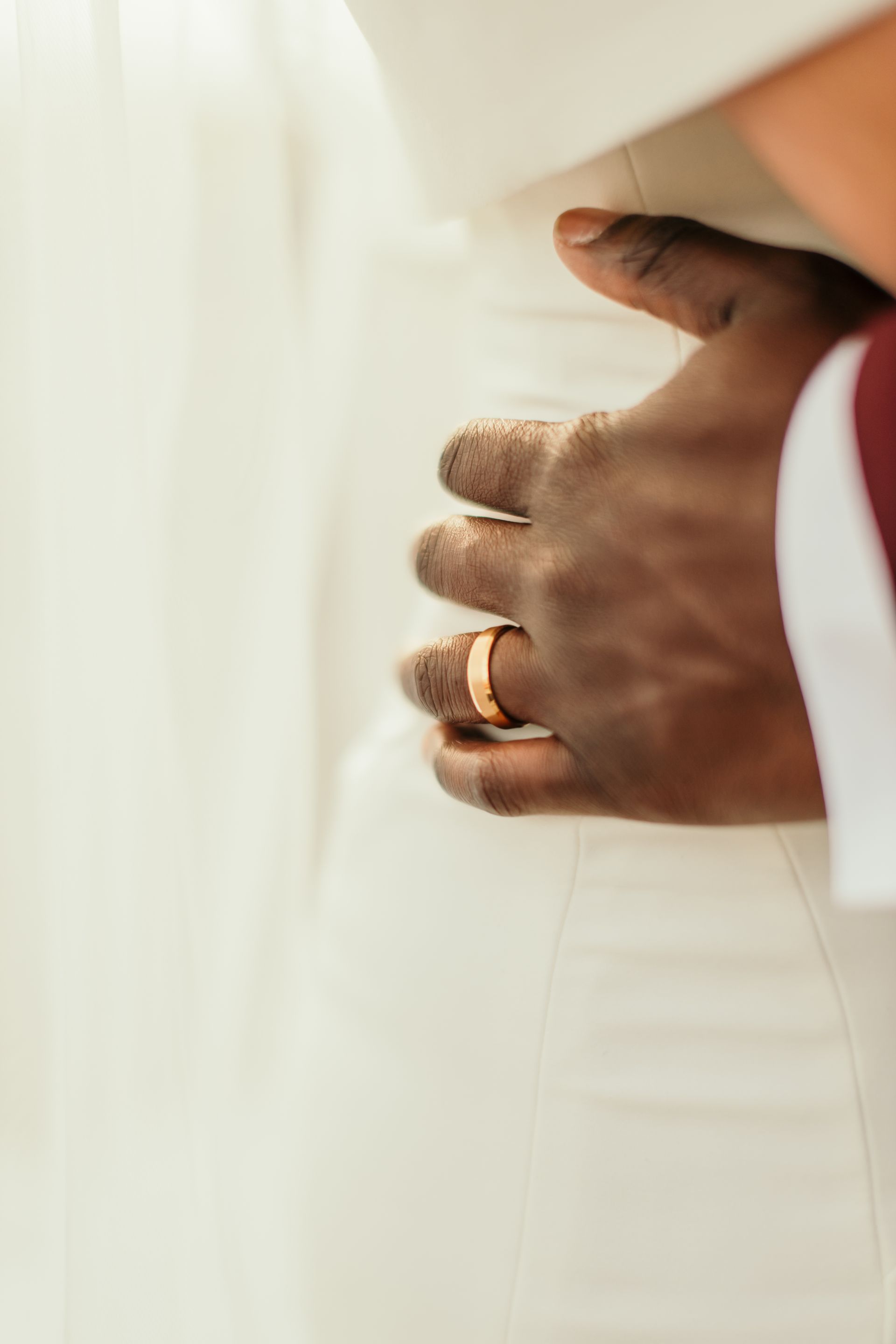 A close up of a man 's hand with a wedding ring on it.