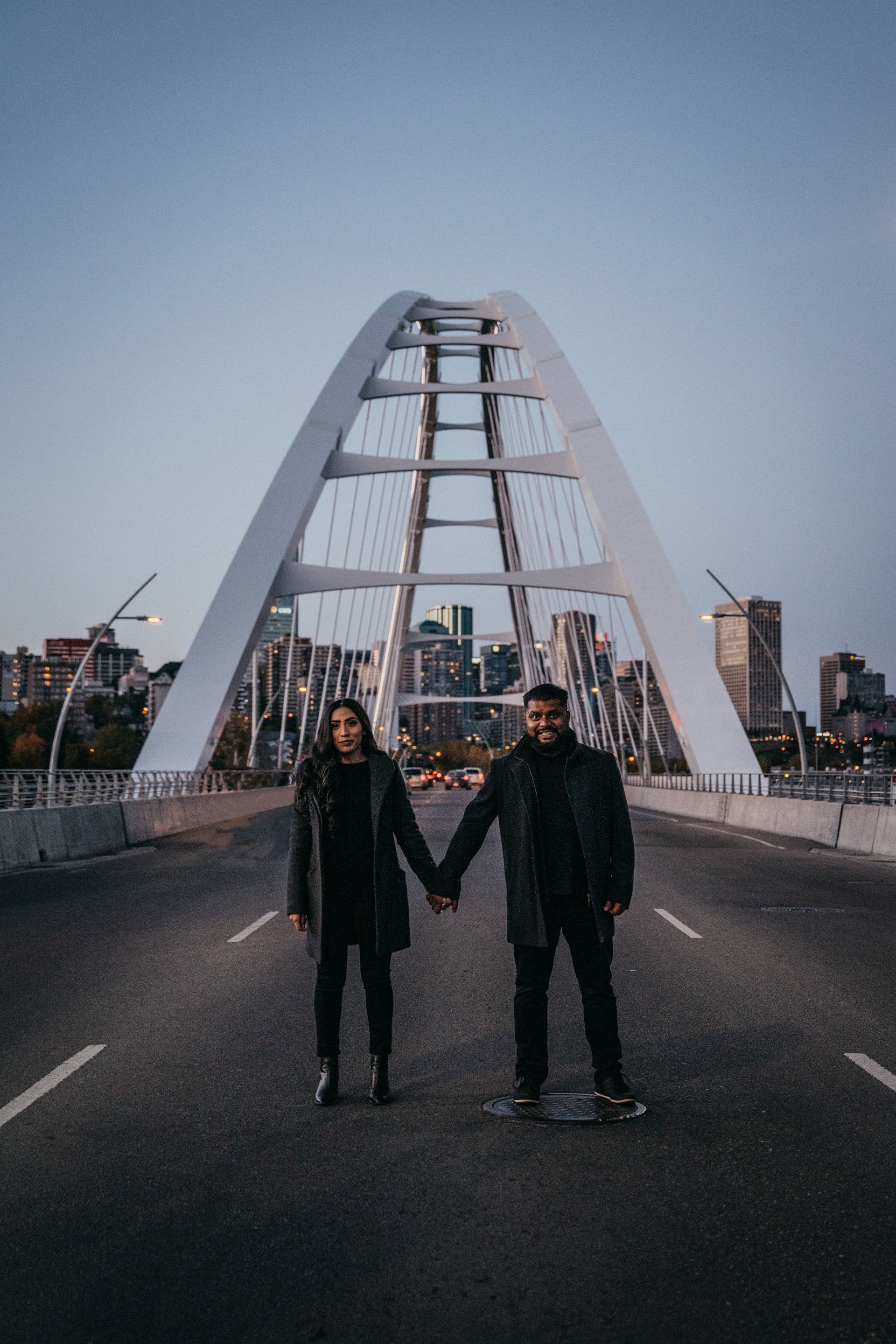 A man and a woman are holding hands on a bridge.
