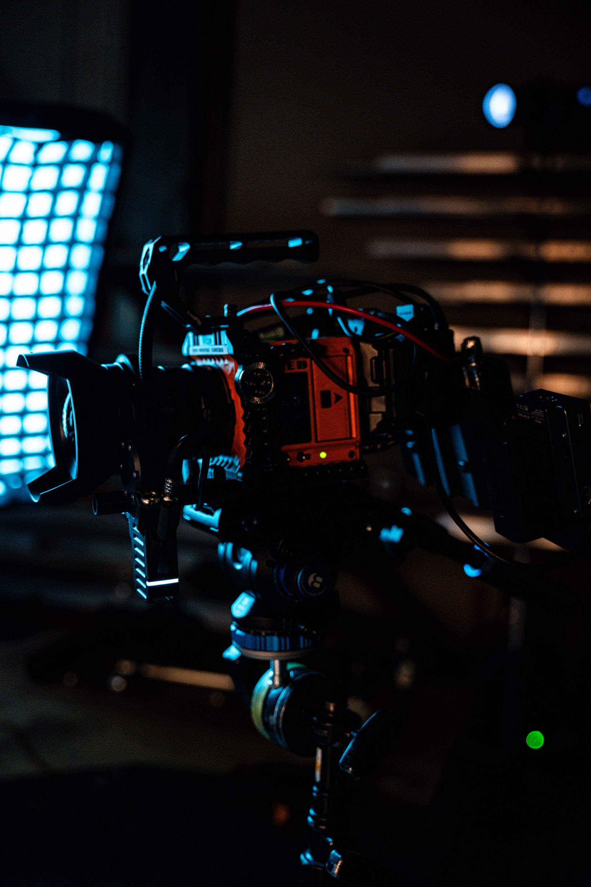 A camera is sitting on a tripod in a dark room.