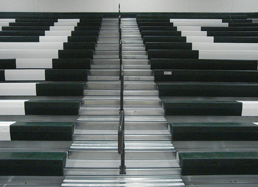 Straight shot of Interkal quarter-turn aisle rails in the open position on a fully extended telescopic bleacher.