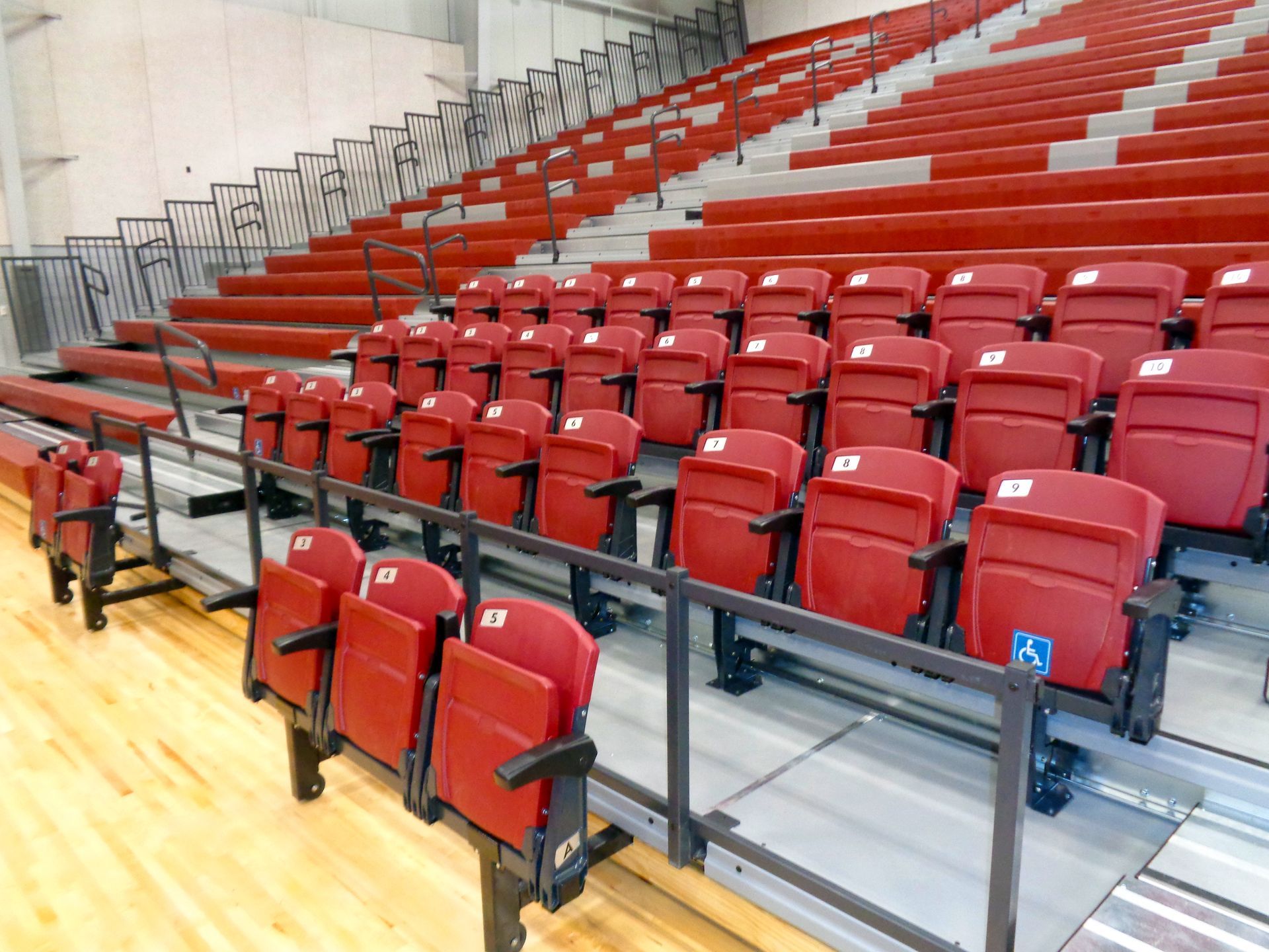 Red VISION Platform chairs with armrests on a wide format premier platform in standard grey. 