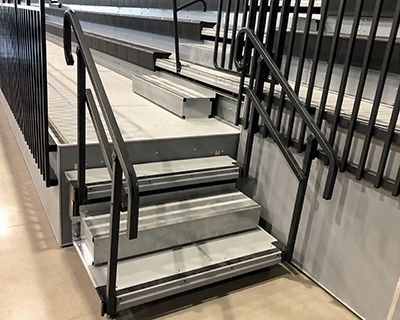 Elevated front and rear walkways for telescopic bleacher installations