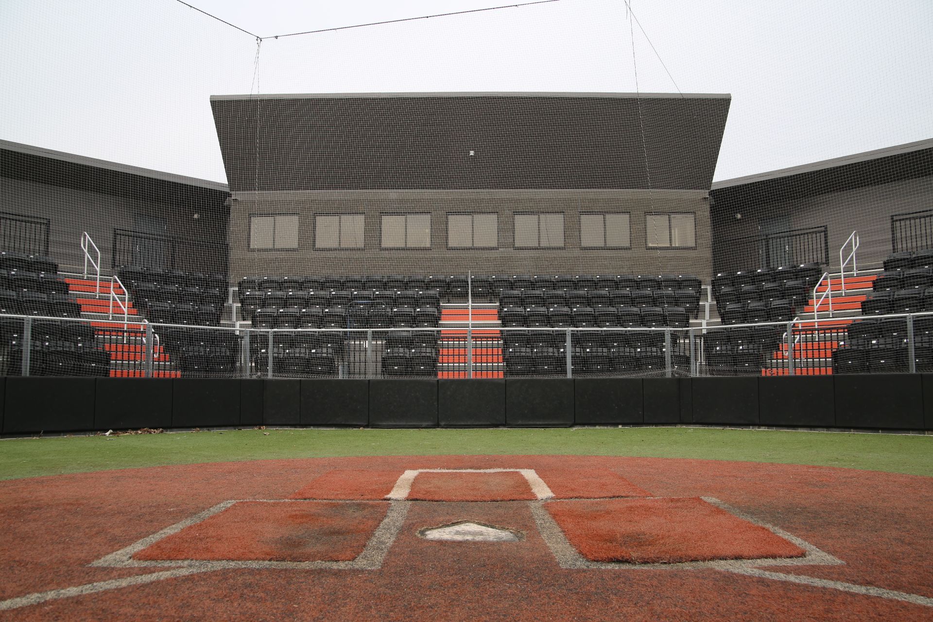 A view of the Brother Rice Warrior Stadium from homeplate, showing a wide view of black AURA Slat Stadium chairs for seating.