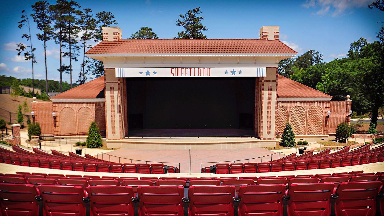 Burgundy Interkal AURA Slat Stadium Chairs with armrests with cupholders in the outdoor amphitheater at Boyd Sweetland.