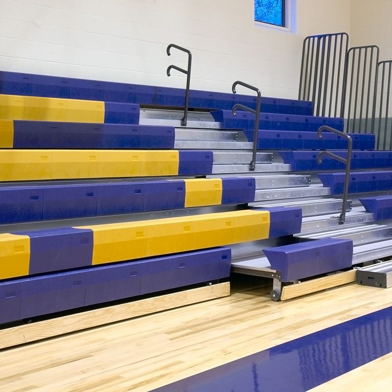 Telescopic bleachers with the ADA compliant notchout engaged, highlighting the amount of space provided for team seating.