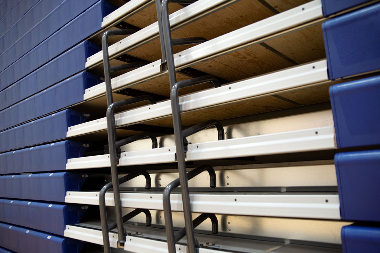 Blue Interkal EXCEL Seat Modules color the massive high-rise telescopic bleacher installation at the Dewitt High School gym.