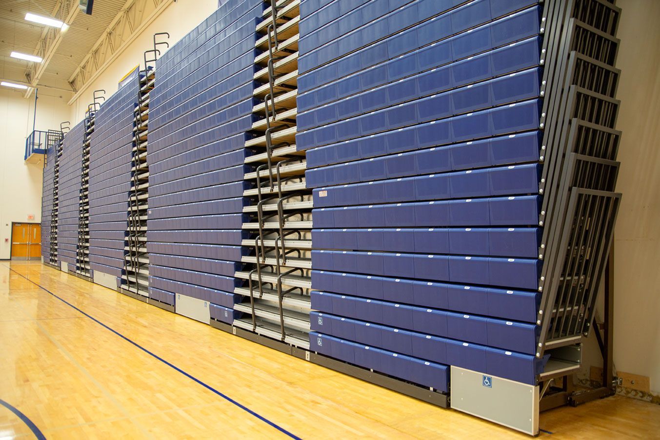 Blue Interkal EXCEL Seat Modules color the massive high-rise telescopic bleacher installation at the Dewitt High School gym.
