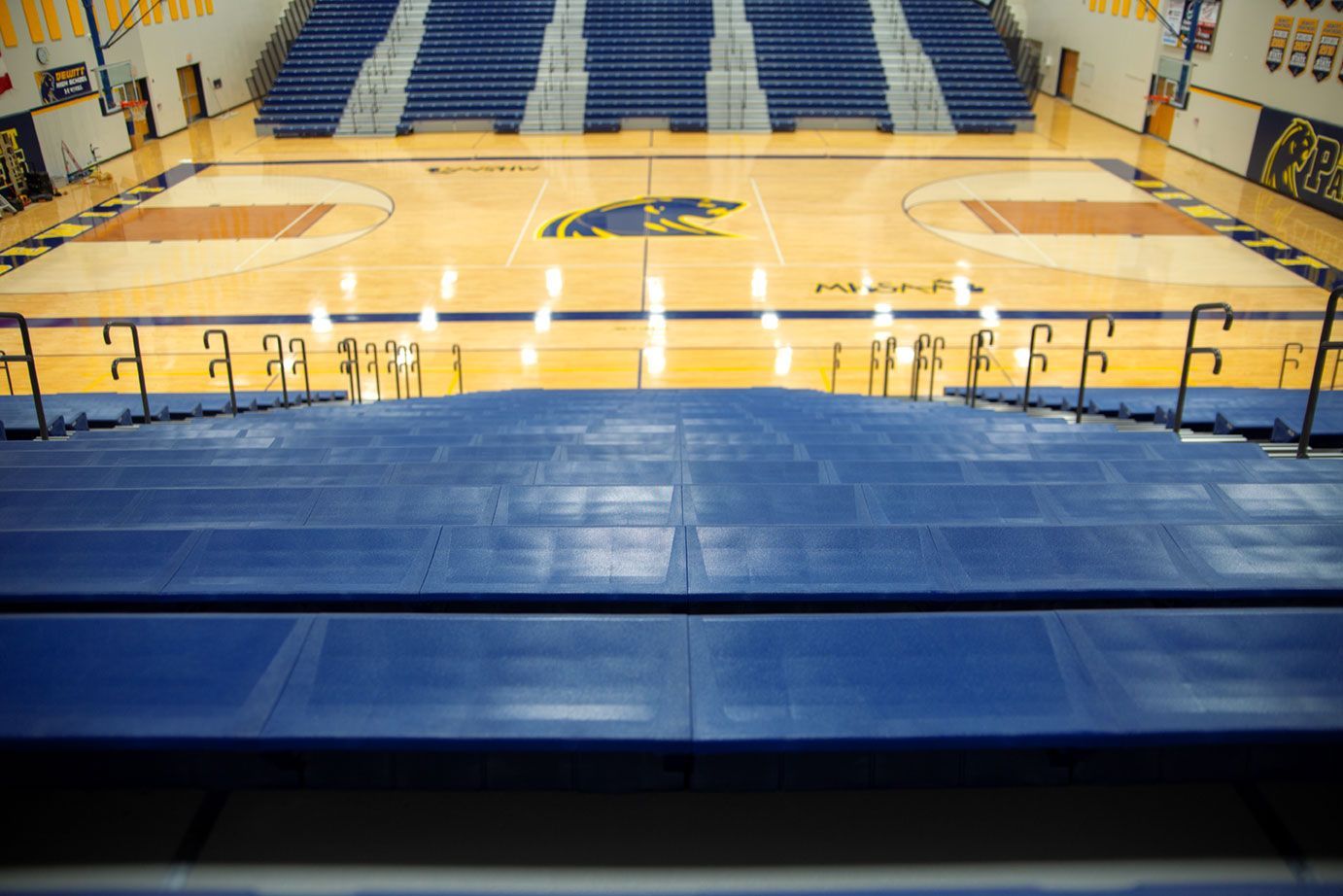 Blue Interkal EXCEL Seat Modules color the massive high-rise telescopic bleacher installation at the Dewitt High School gym.