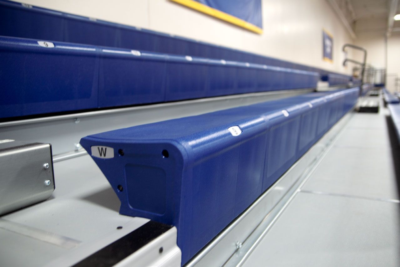 Blue Interkal EXCEL Seat Modules color the massive high-rise telescopic bleacher installation at the Dewitt High School gym.