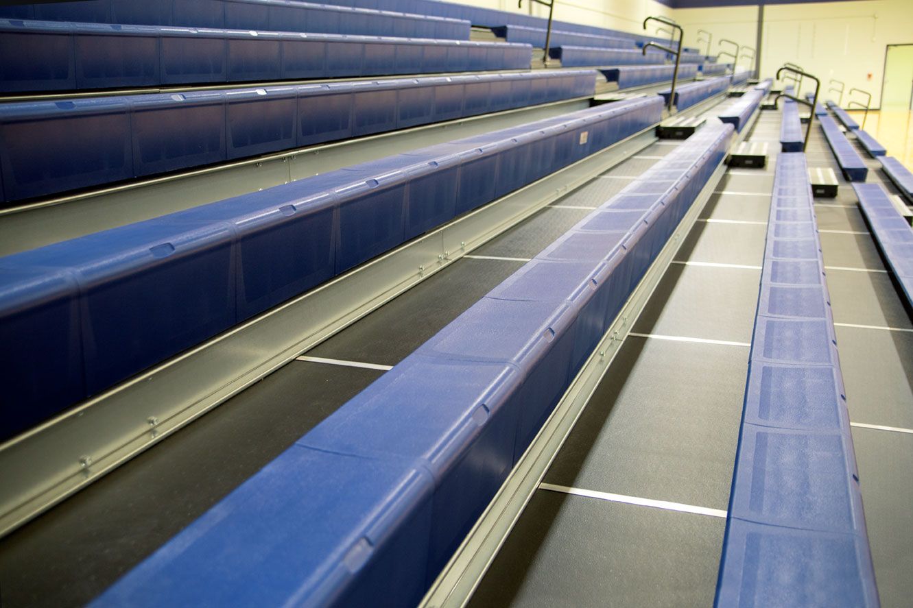 The gymnasium at Gull Lake Middle School, featuring Blackout B1 tier with blue EXCEL seat modules, self-storing aisle rails.