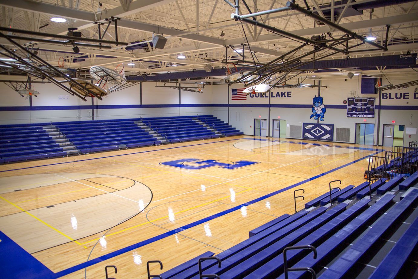 The gymnasium at Gull Lake Middle School, featuring Blackout B1 tier with blue EXCEL seat modules, self-storing aisle rails.