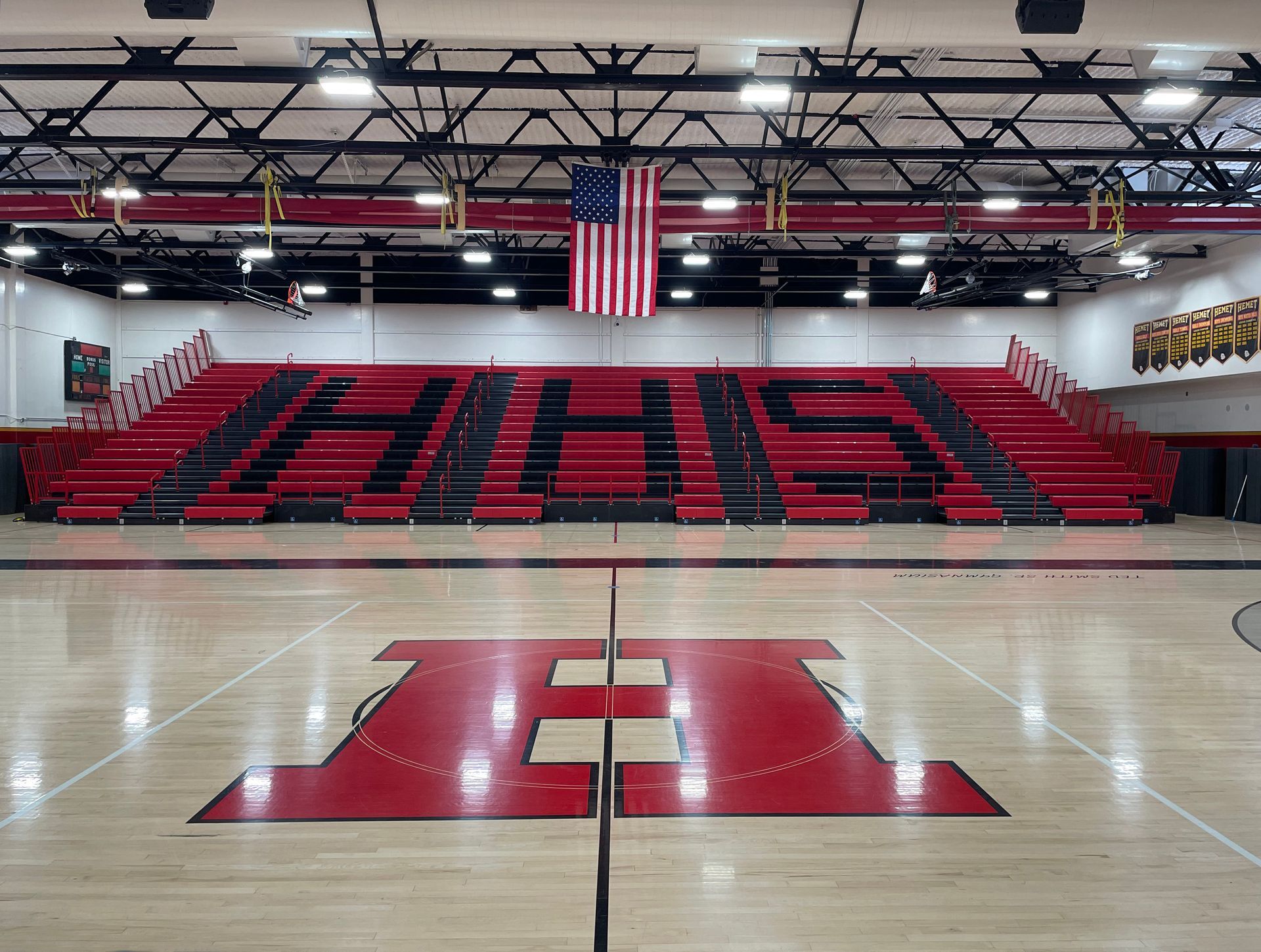 The telescopic bleacher system at Hemet High School in California, featuring custom red aisle rails and school initials.