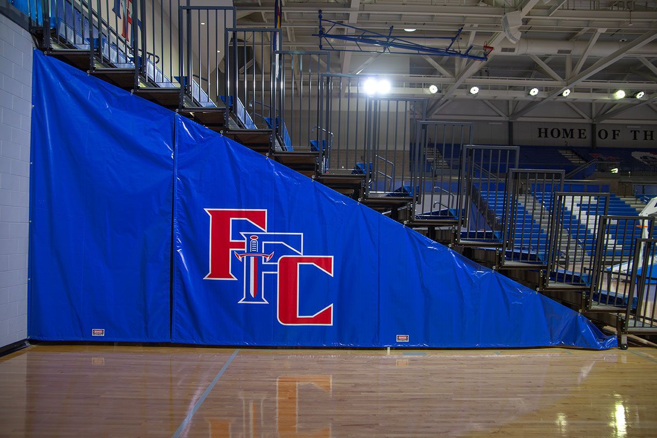 The gymnasium floor at Trojan Arena in CO that features EXCEL Seat Modules in red, white and blue colors for a striking look!