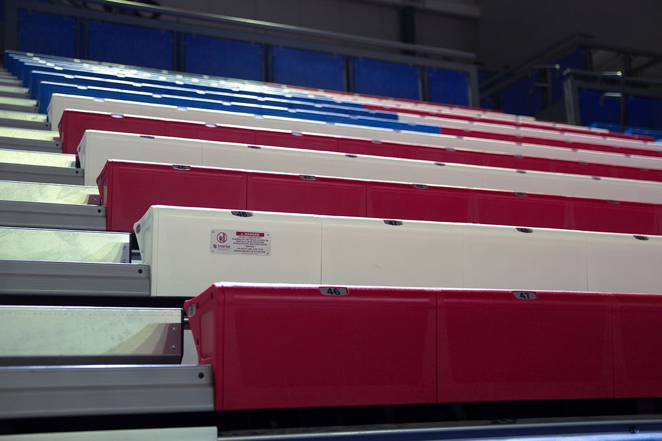 The gymnasium floor at Trojan Arena in CO that features EXCEL Seat Modules in red, white and blue colors for a striking look!