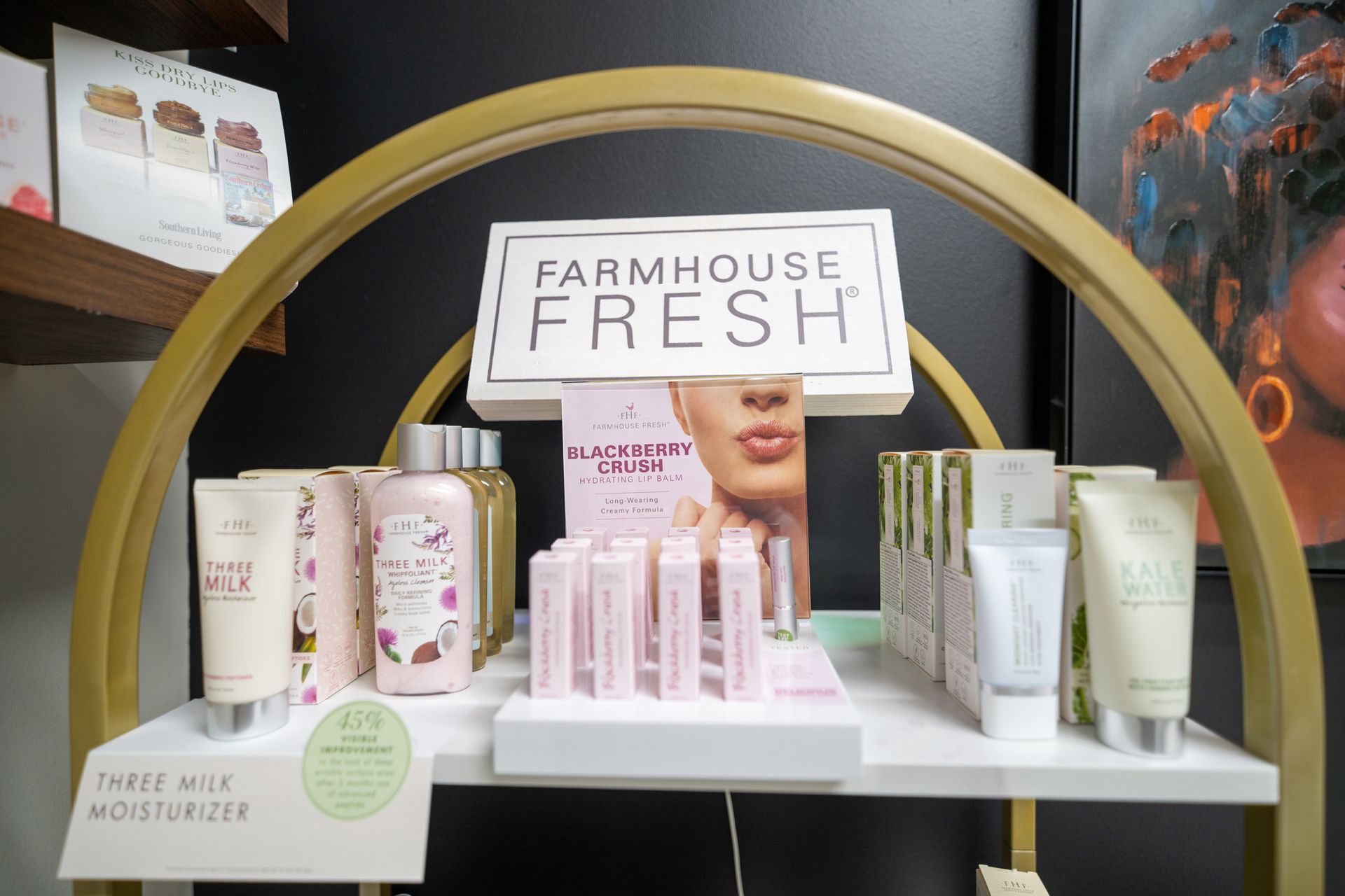 Farmhouse Fresh skincare display on a white shelf. Pink and white products are arranged on a golden arch structure.