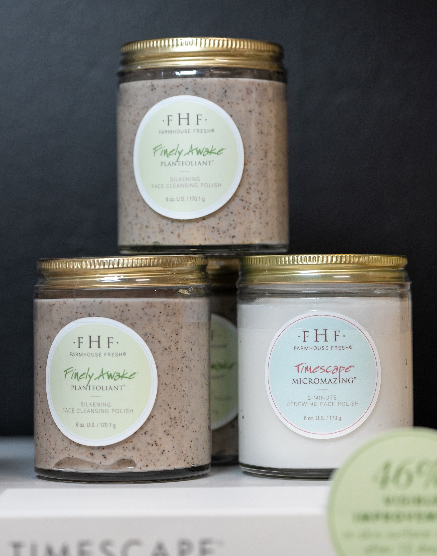 Three jars with gold lids and labels, stacked on a white surface. Two jars are brown, one is white.