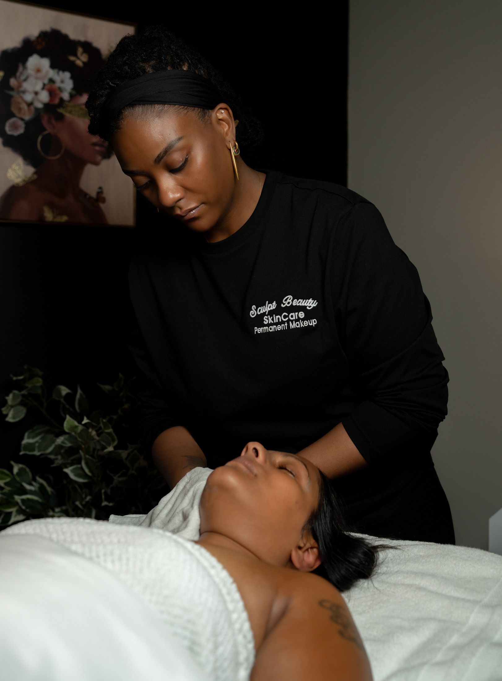 Woman giving a massage to a client on a massage table in a spa.