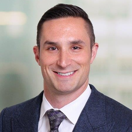A man in a suit and tie is smiling for the camera.