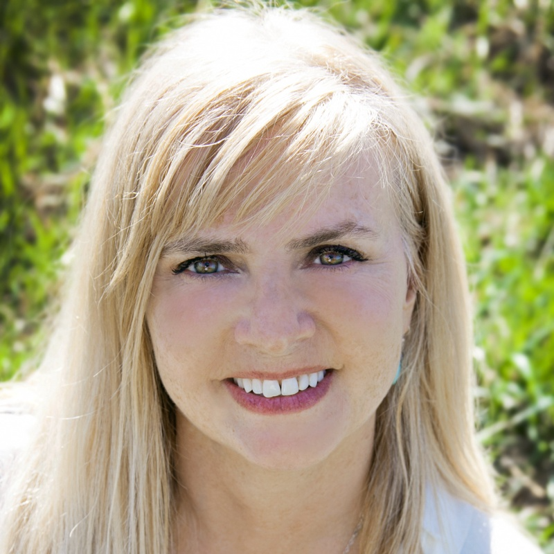 A woman with blonde hair is smiling for the camera