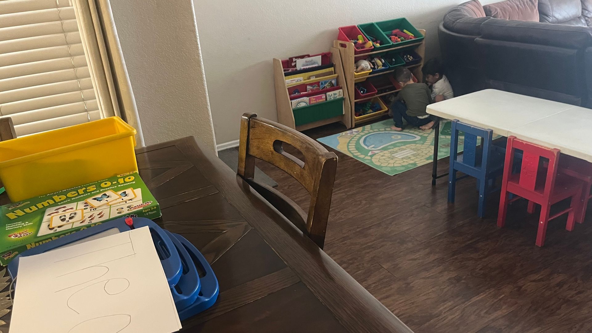 Wooden toy train candle holders on a table, with a cake in the background.