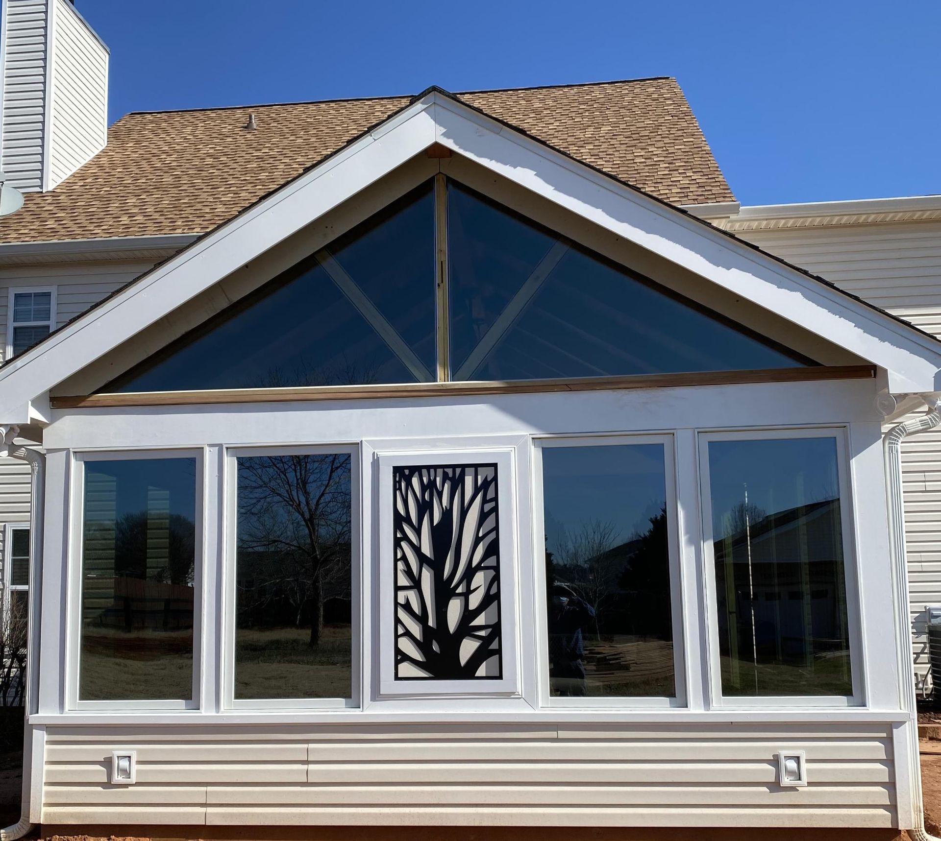 A house with a triangle shaped roof and lots of windows