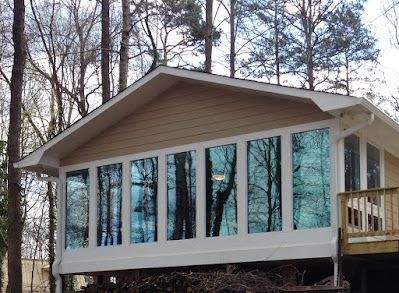 A house with a lot of windows and trees in the background.