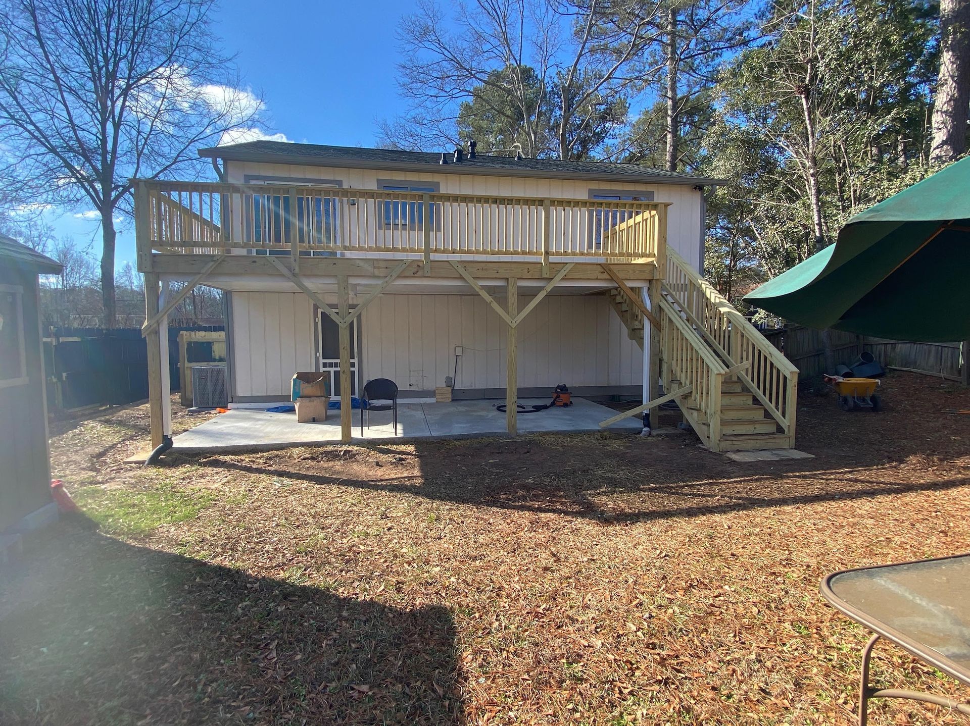 A house with a large deck and stairs in the backyard.