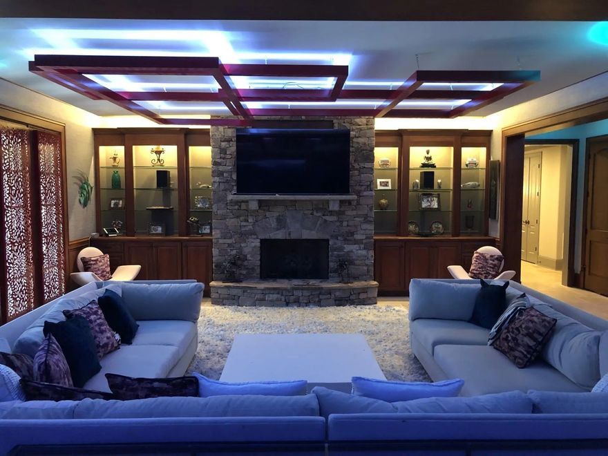 A living room with a couch , fireplace and television.
