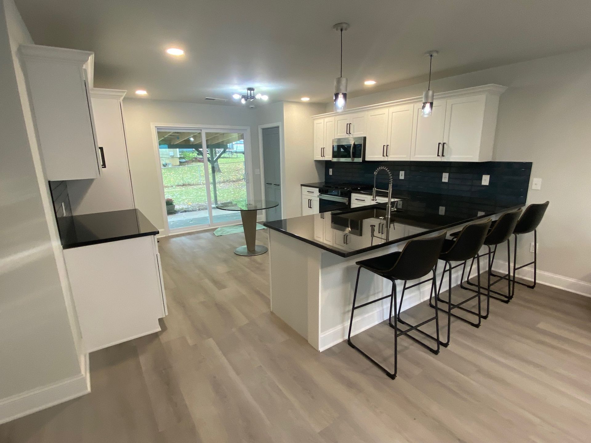 A kitchen with a large island and stools in a house.
