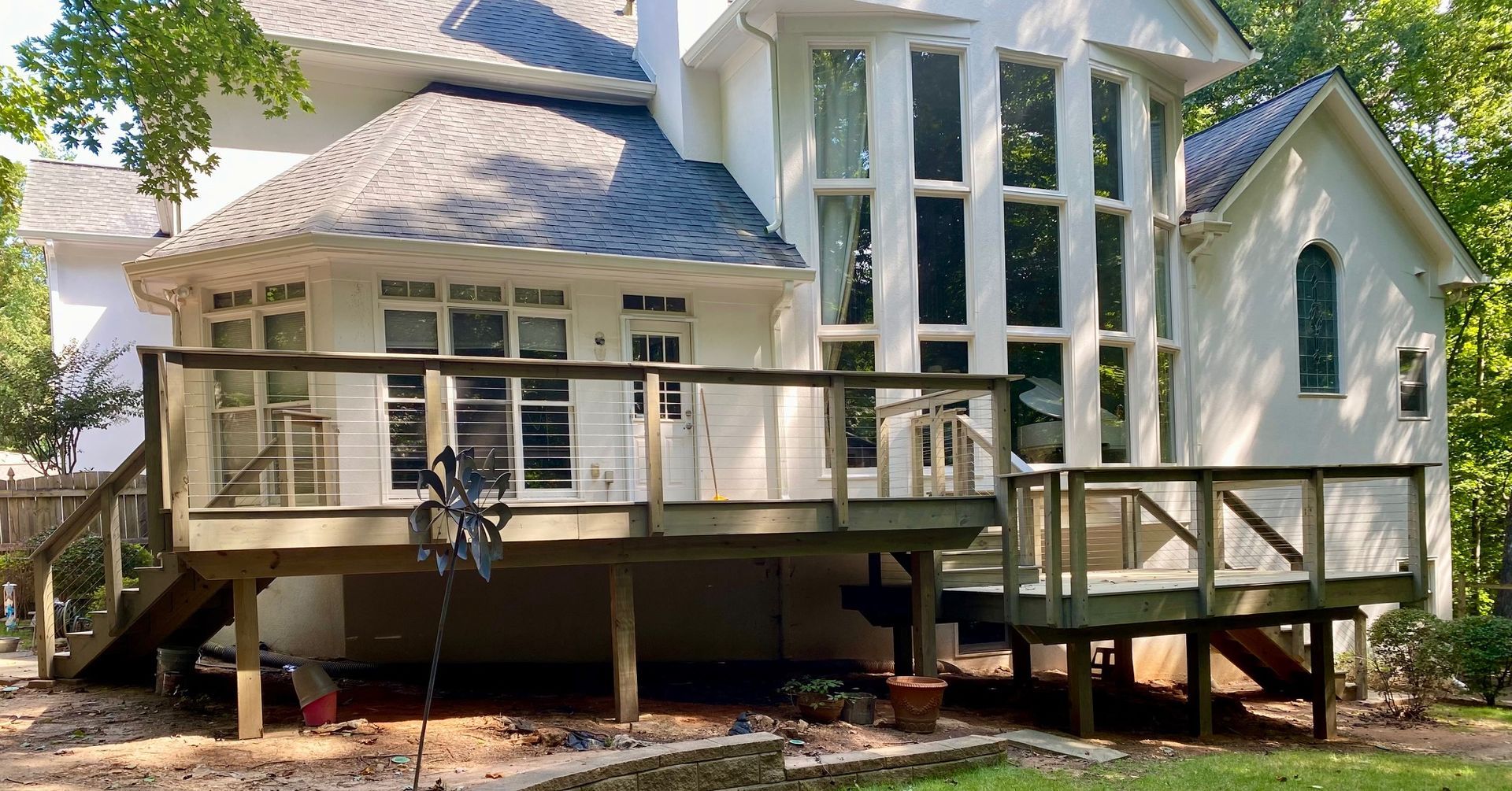 A large white house with a large deck in front of it.
