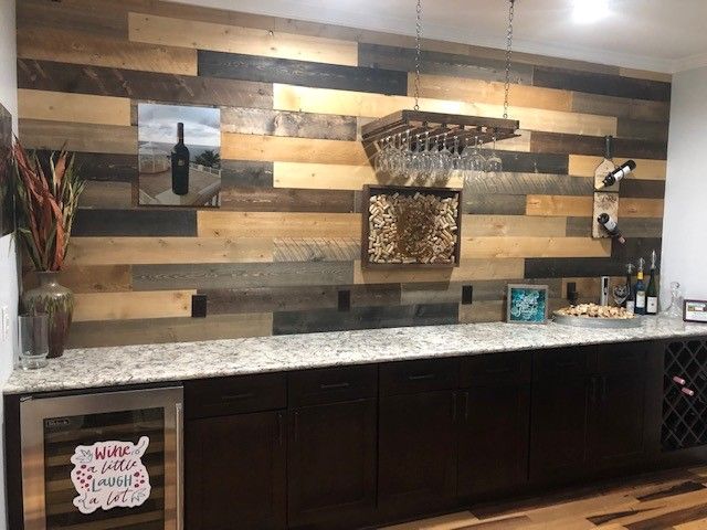 A kitchen with a wooden wall and a wine cooler.