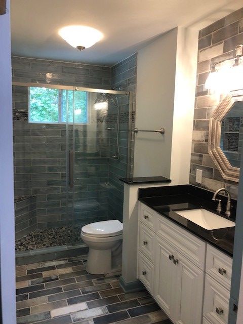 A bathroom with a toilet , sink and shower.