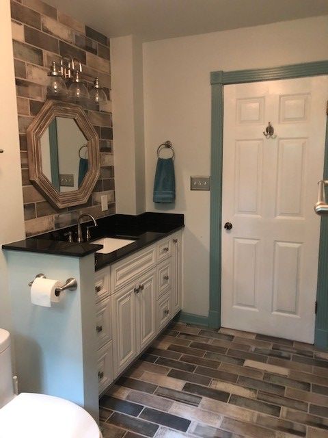 A bathroom with a toilet a sink and a mirror