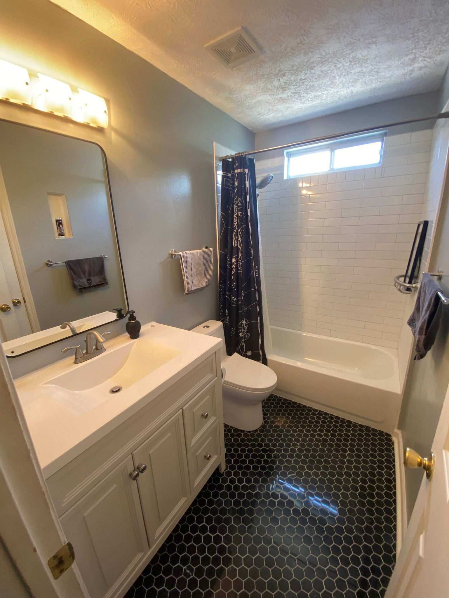 A bathroom with a sink , toilet , shower and bathtub.