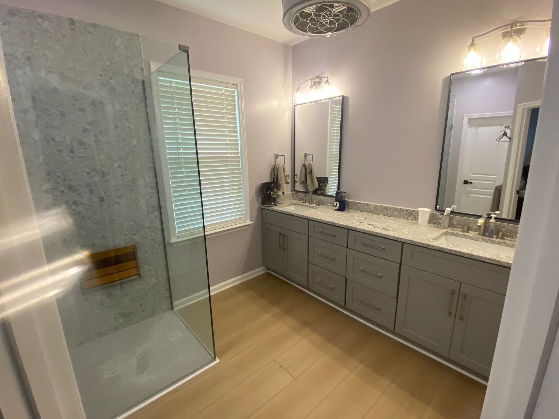 A bathroom with two sinks and a walk in shower.