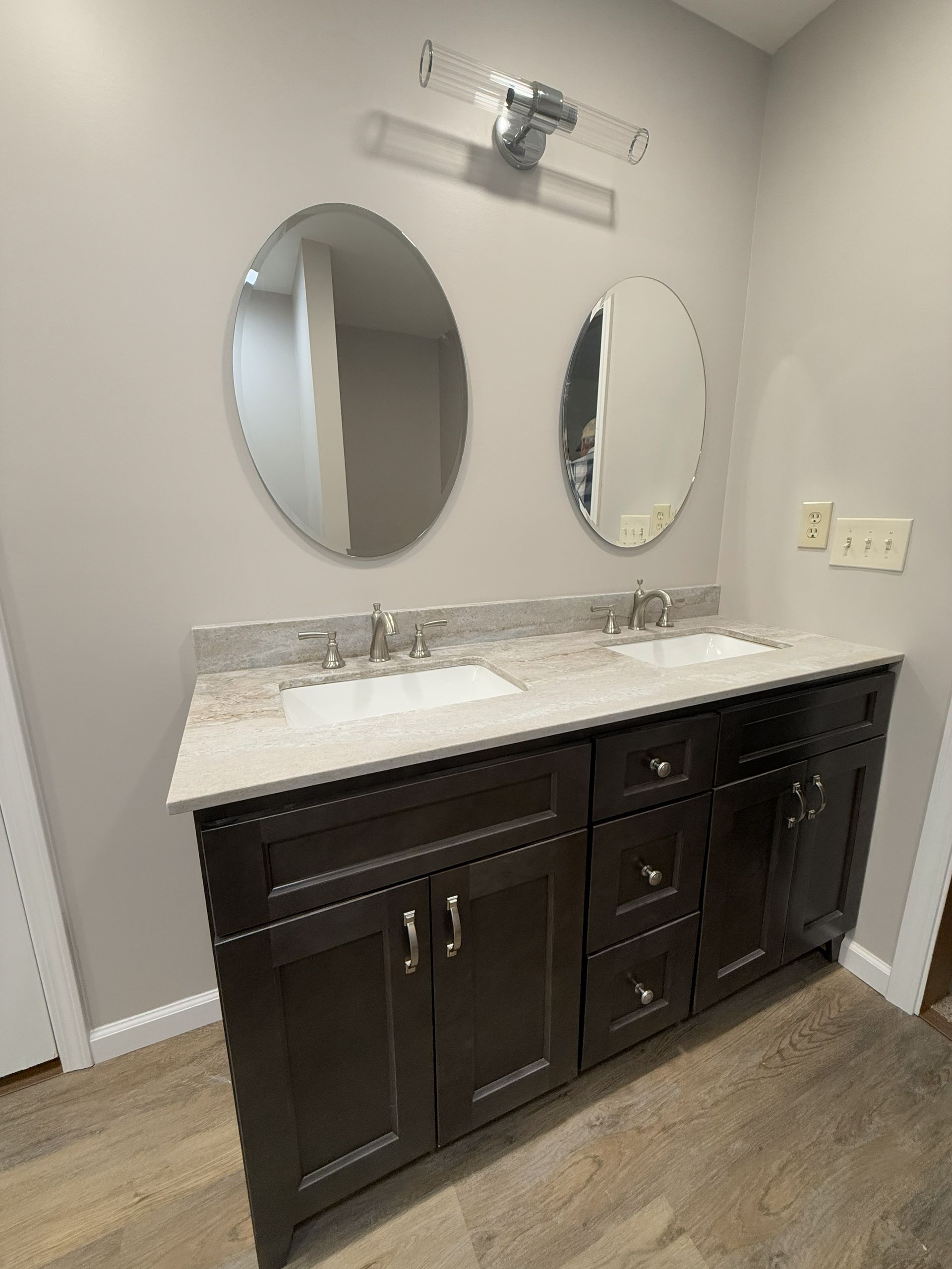 A bathroom with two sinks , a mirror and a window.
