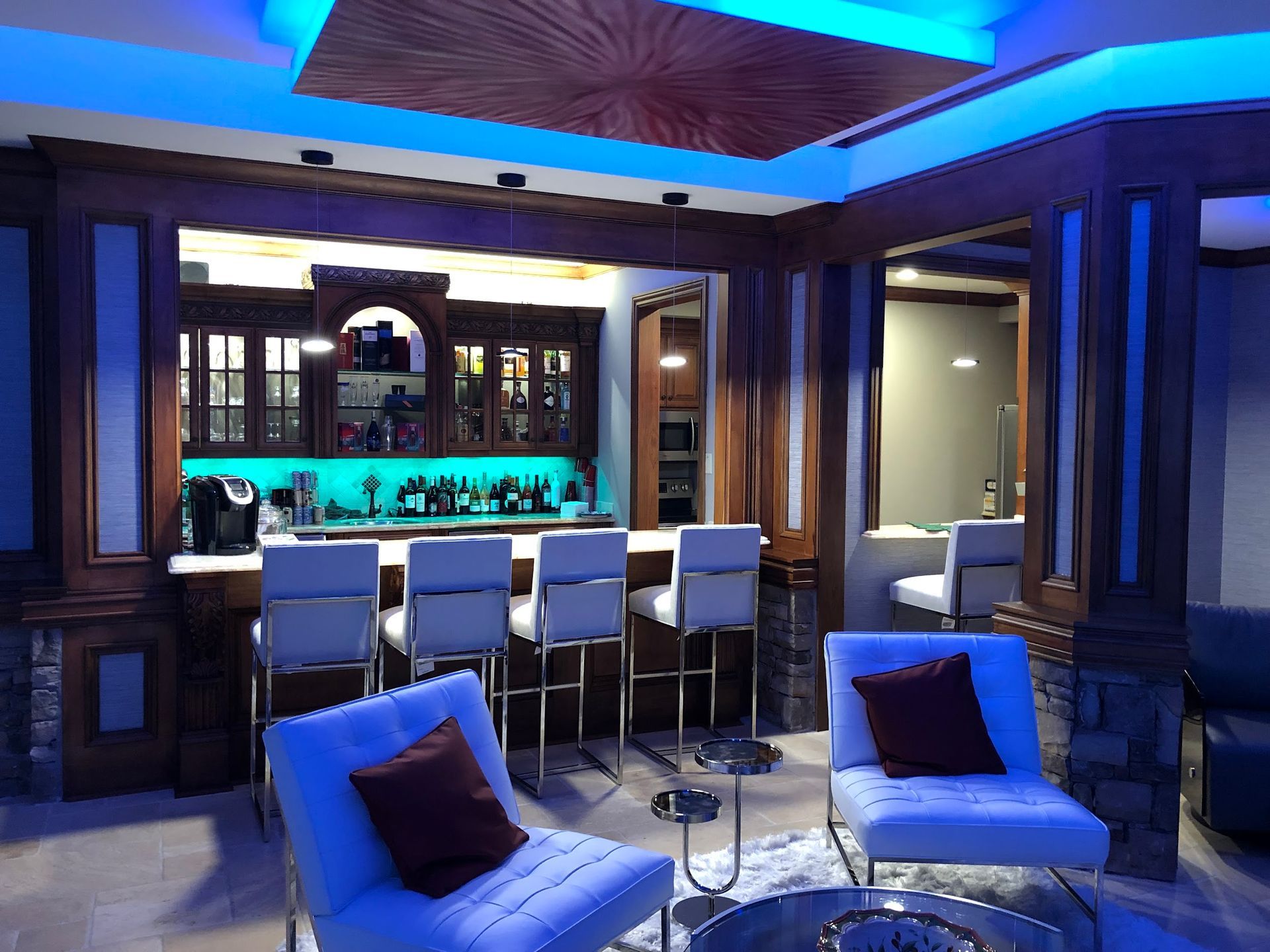 A living room with a bar and chairs in it