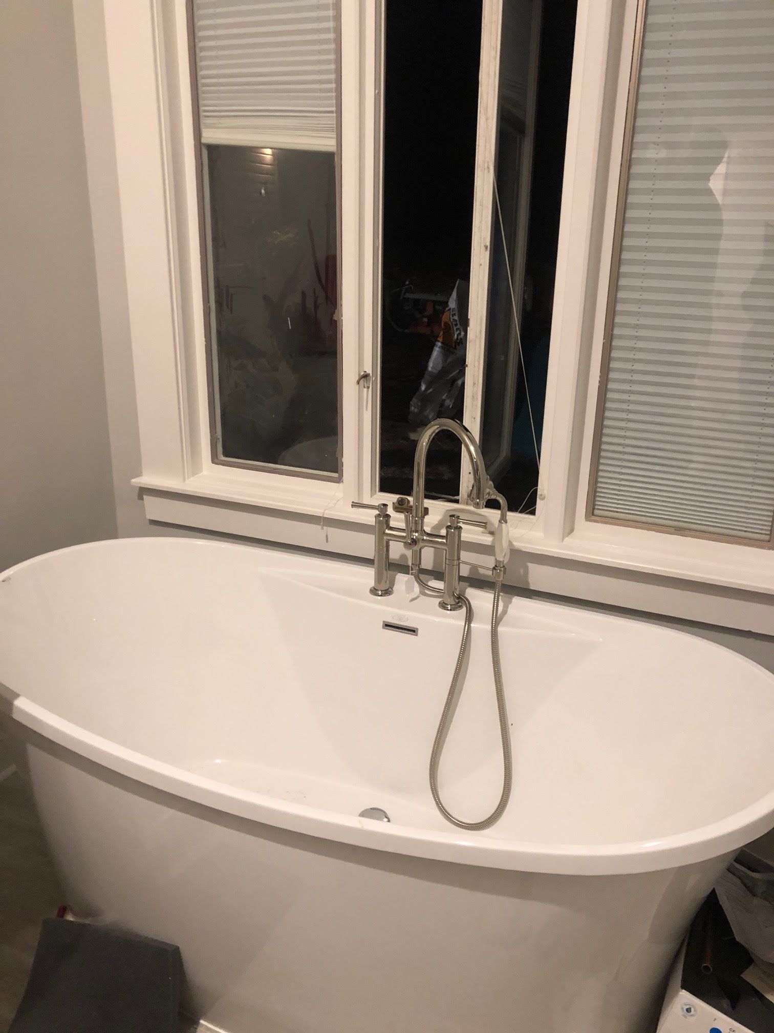 A white bathtub is sitting in a bathroom next to a window.