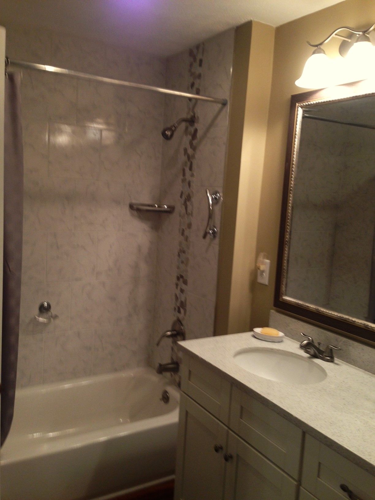 A bathroom with a sink a bathtub and a mirror