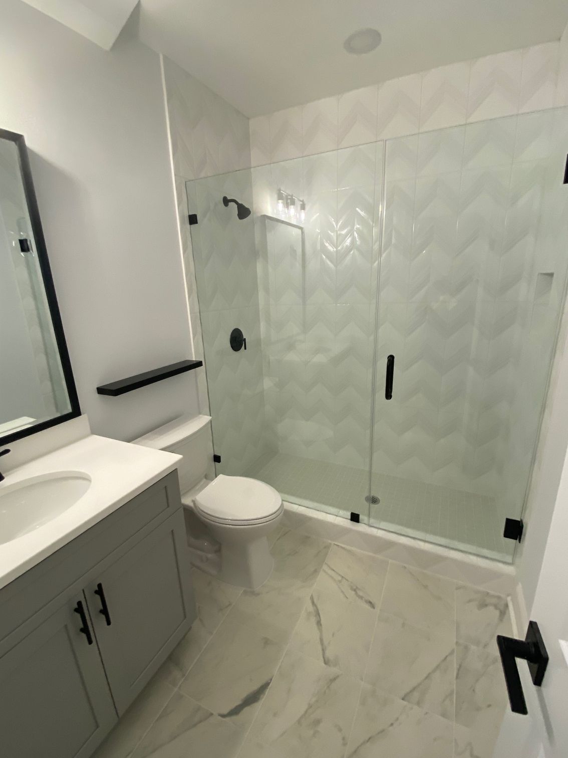 A bathroom with a toilet a sink and a mirror