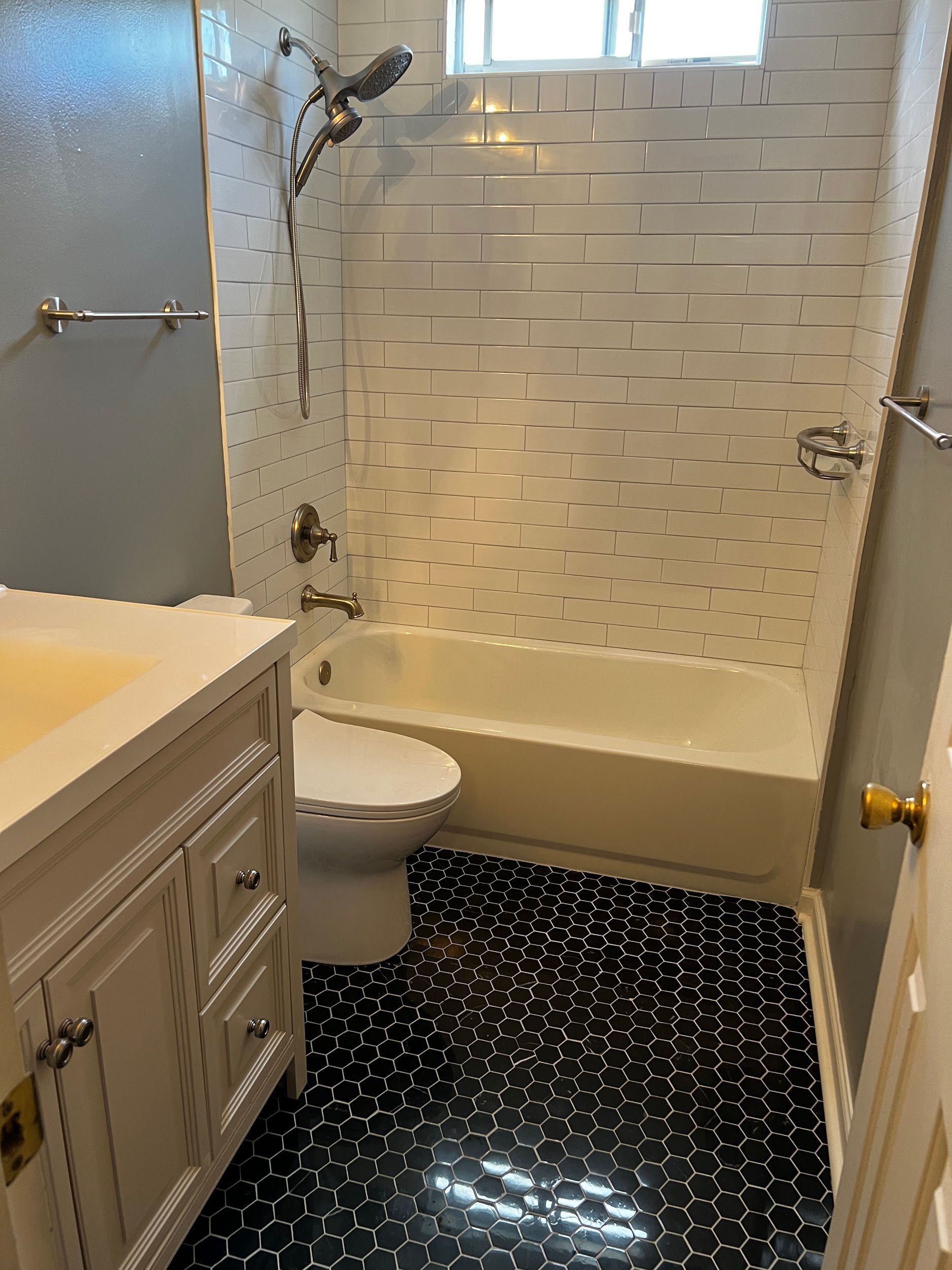 A bathroom with a toilet , sink , bathtub and shower.