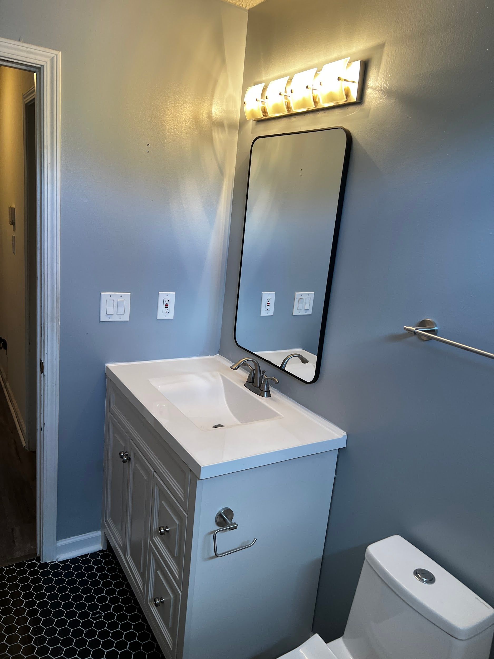 A bathroom with a sink , toilet and mirror.