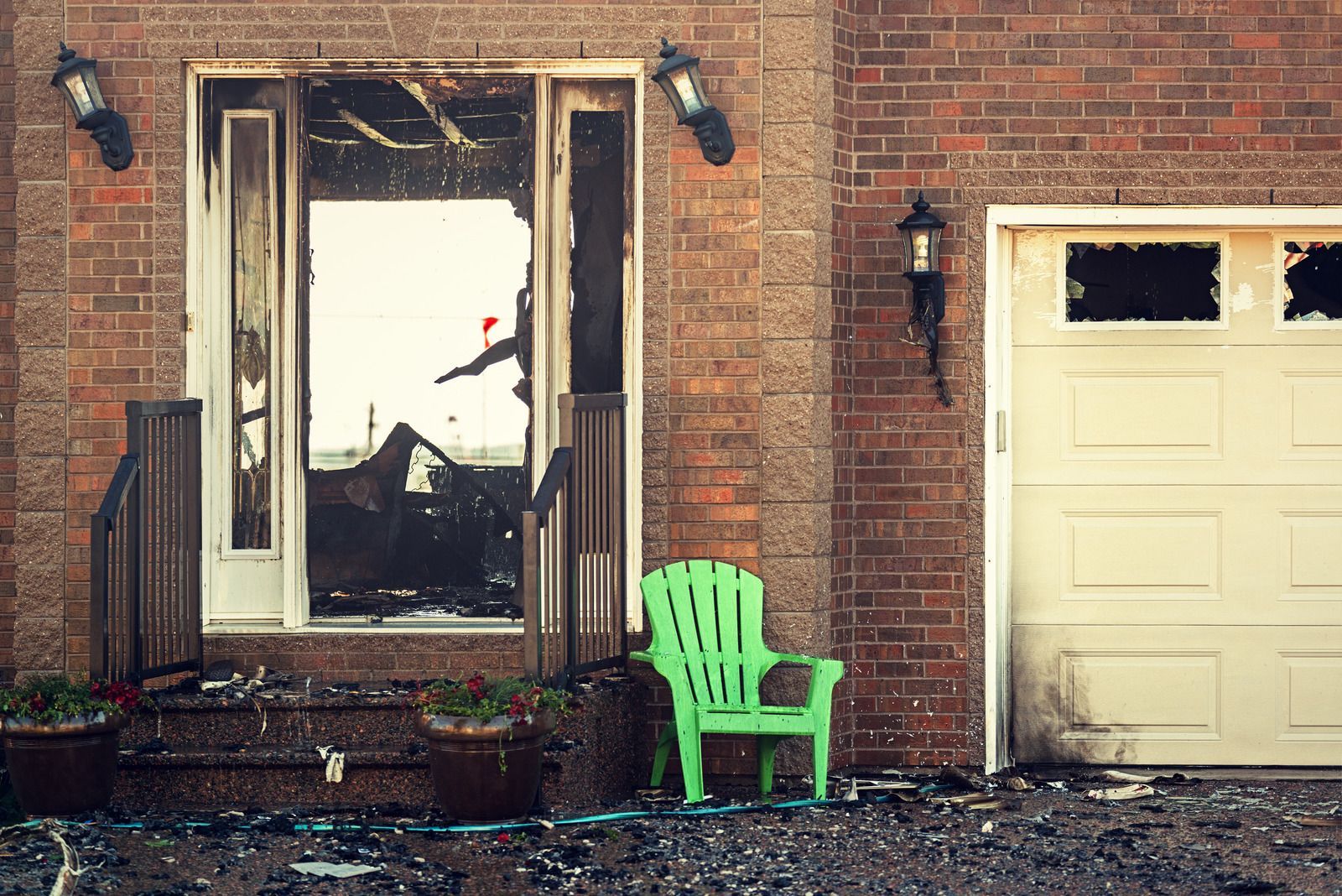 A brick house with a green chair in front of it.