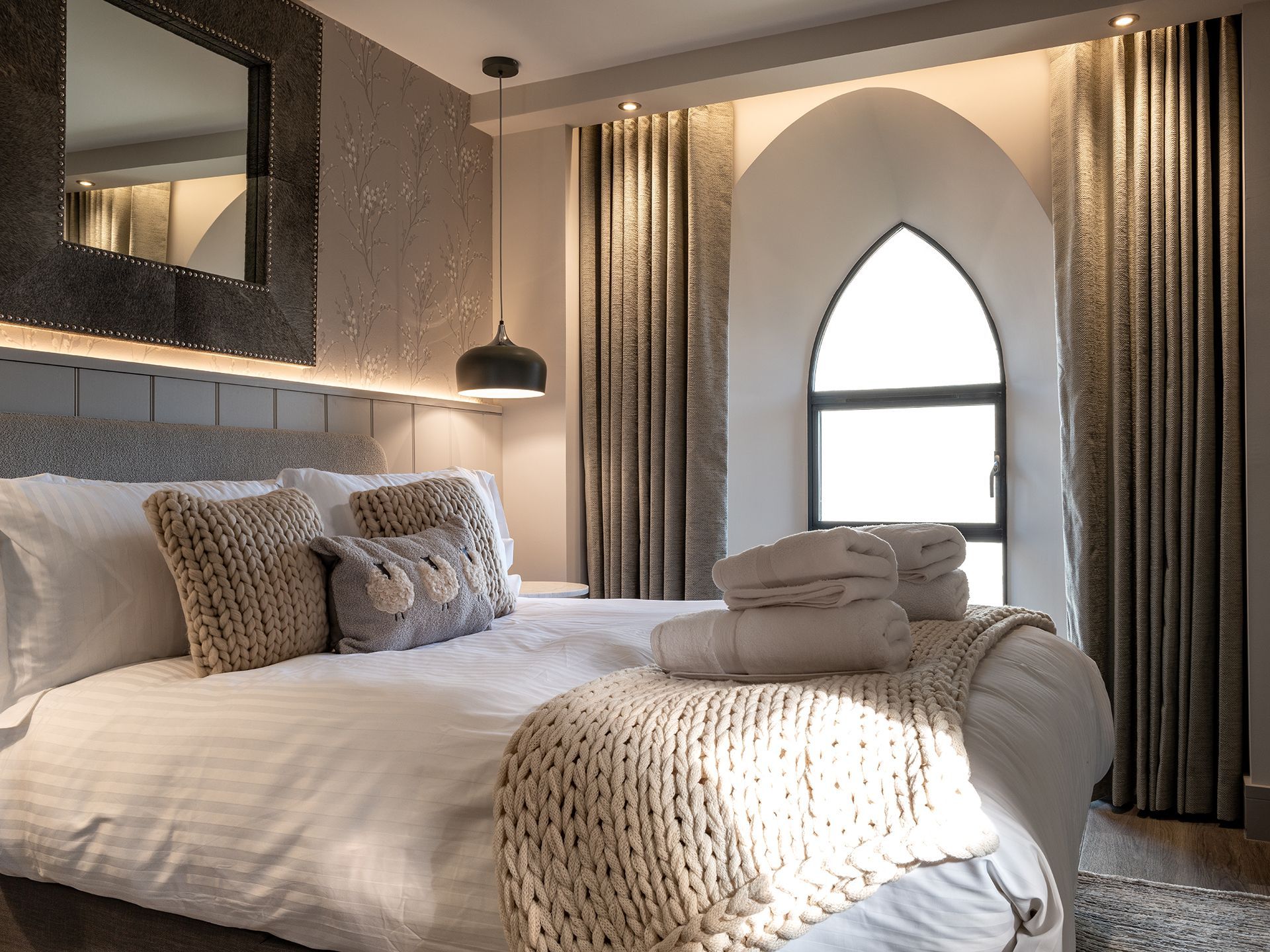 A bedroom with a large bed and a window.