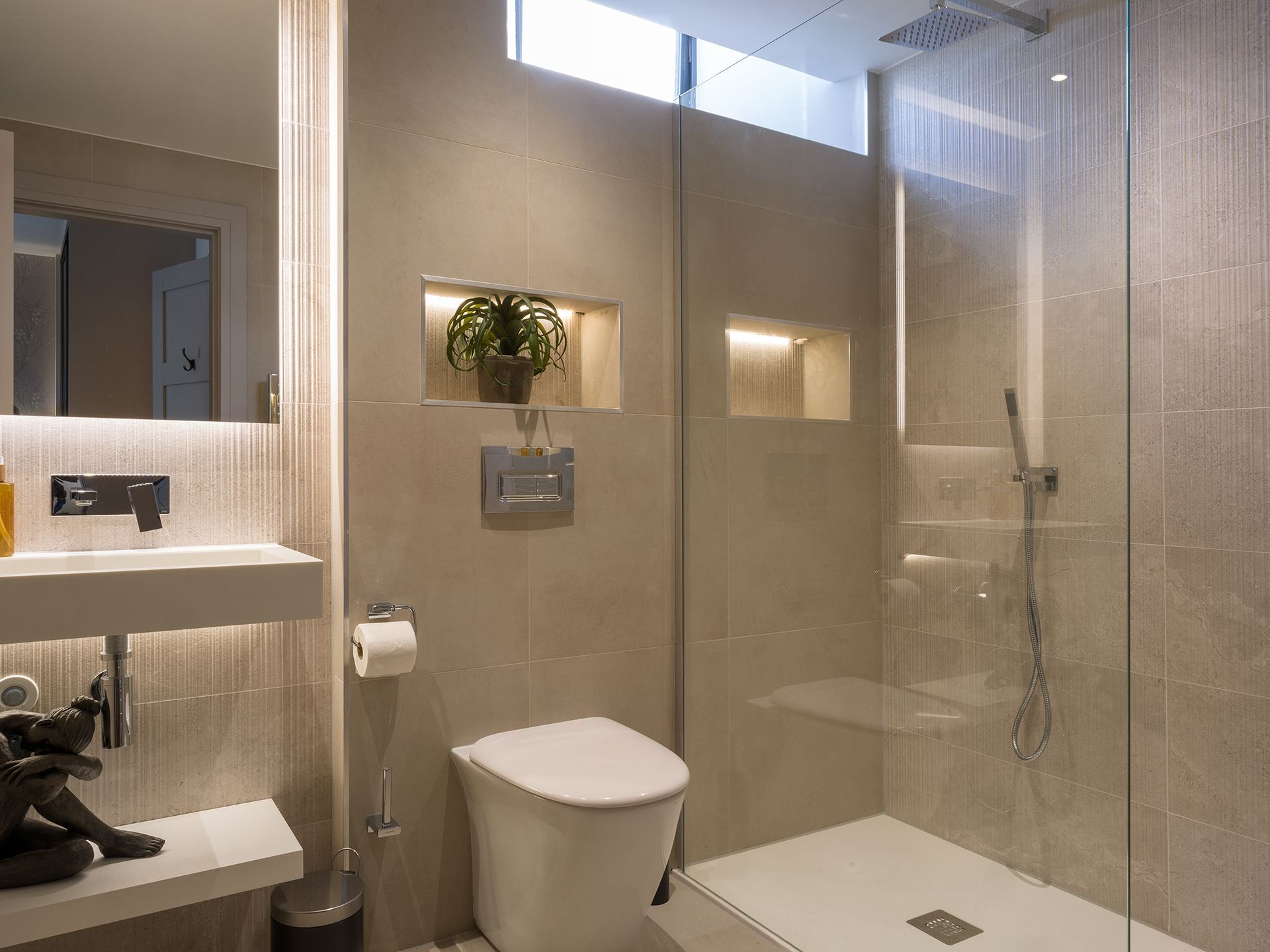 A bathroom with a toilet , sink and walk in shower.