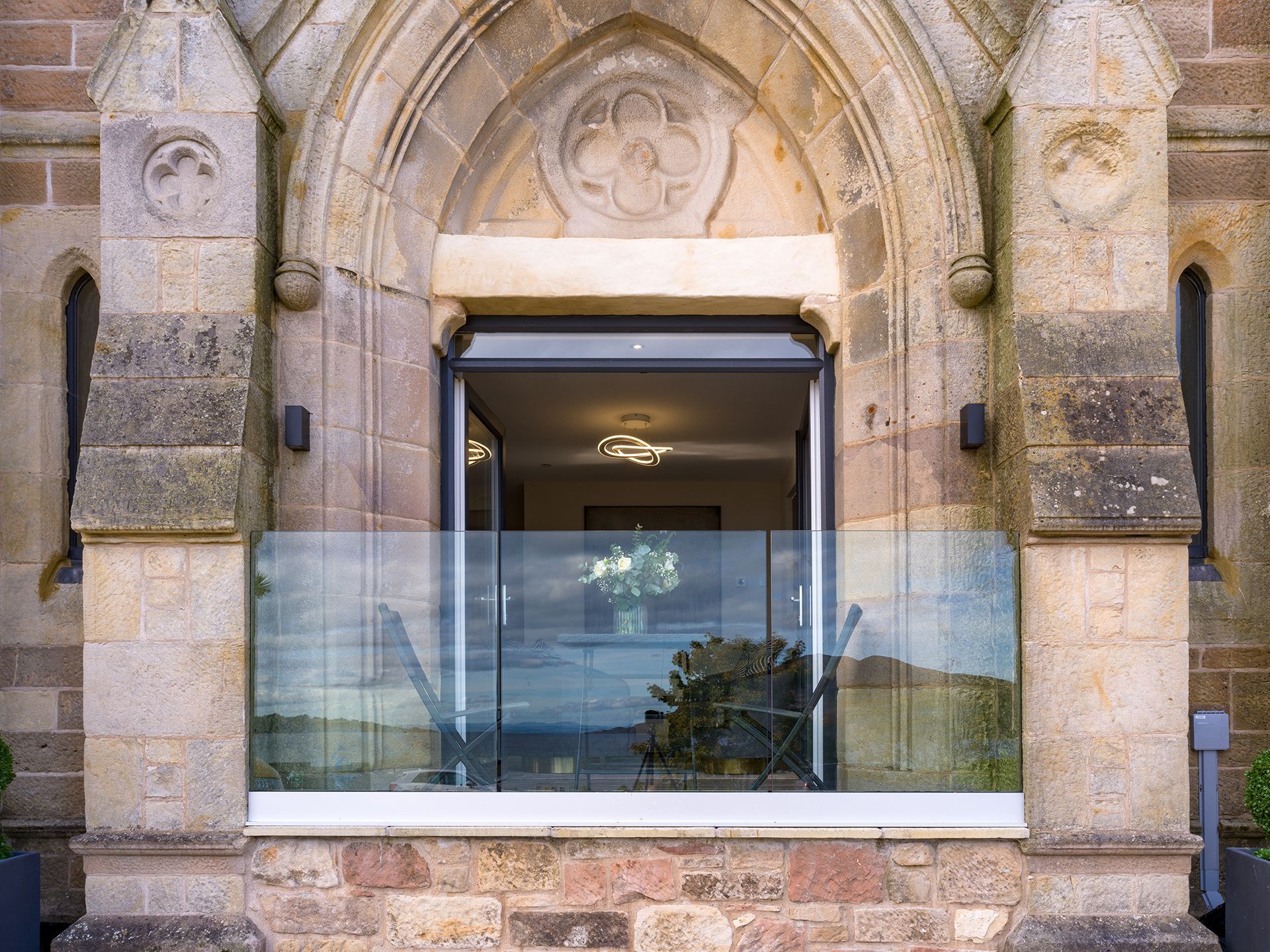 A large window with a glass railing on the side of a building.