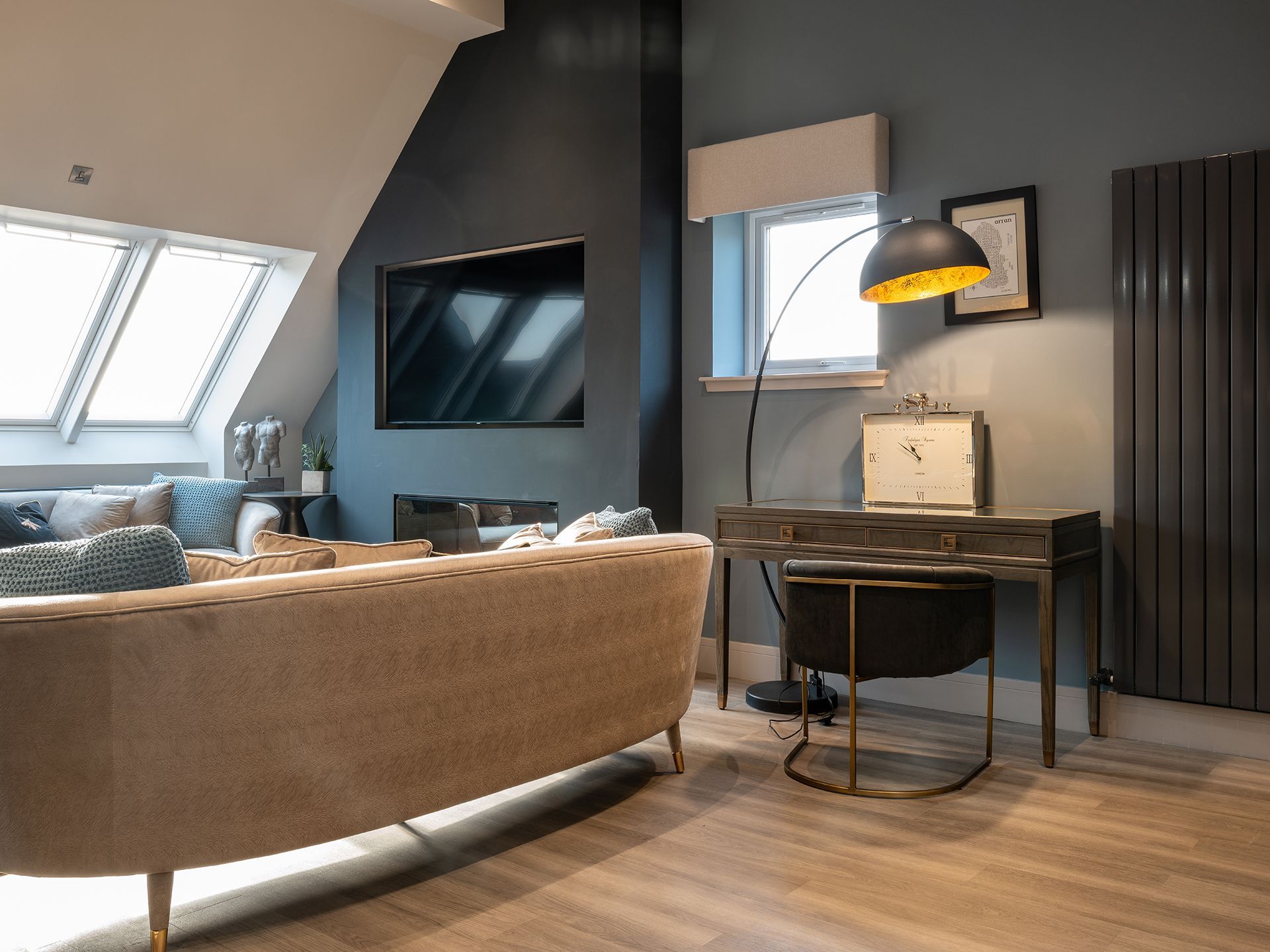 A living room with a couch , desk and television.